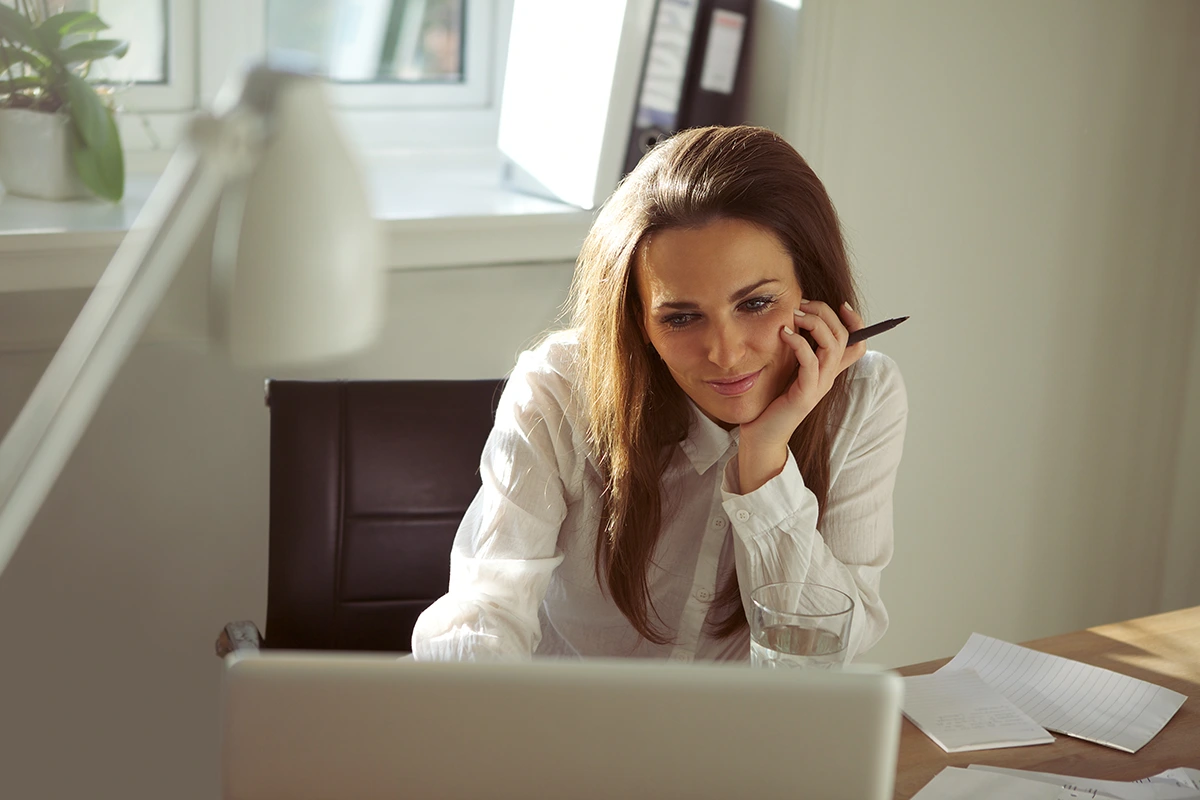 Woman sits at computer to record webinar for her small business.